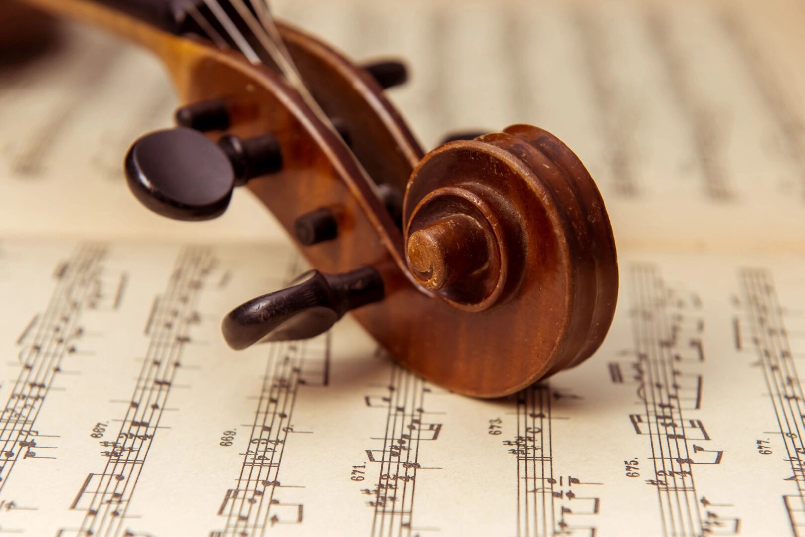 A violin resting on top of sheet music.