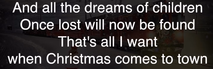Christmas lyric text overlay on snowy town